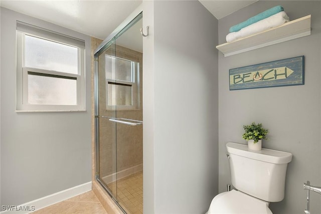 full bathroom featuring a shower stall, baseboards, tile patterned flooring, and toilet