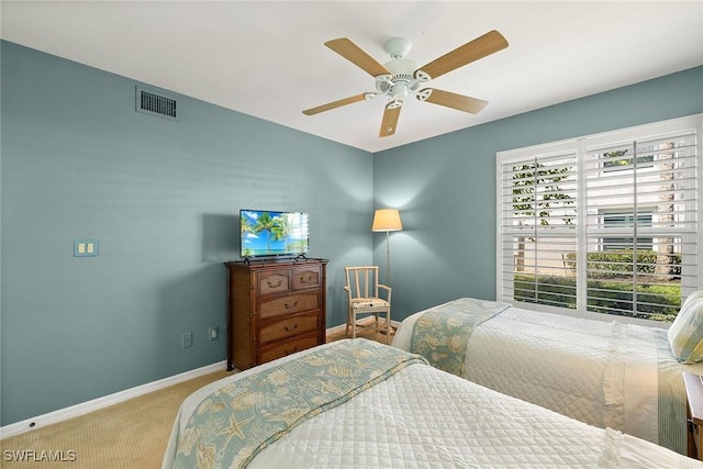 carpeted bedroom with visible vents, baseboards, and a ceiling fan