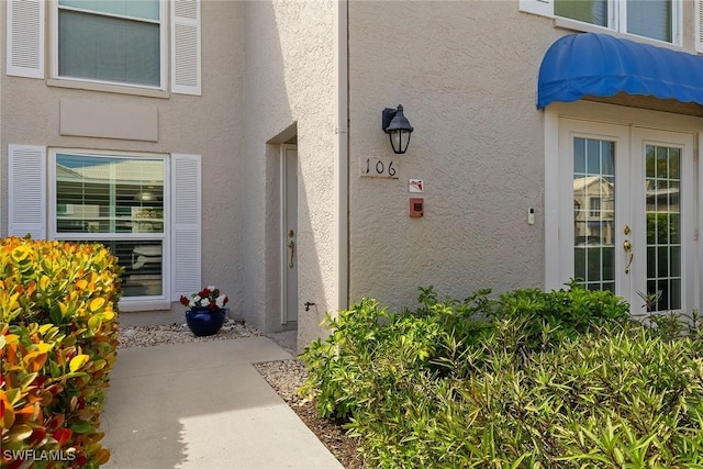 view of exterior entry featuring stucco siding