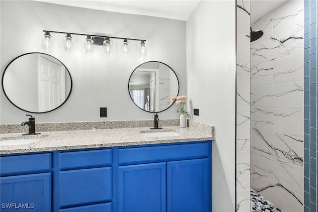 bathroom featuring double vanity, a marble finish shower, and a sink