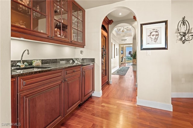 8787 Bay Colony Dr Unit 803, Naples, FL 34108 - indoor wet bar with arched walkways, wood finished floors, and baseboards