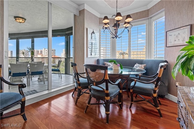 8787 Bay Colony Dr Unit 803, Naples, FL 34108 - dining room featuring crown molding, wood finished floors, a chandelier, wallpapered walls, and baseboards