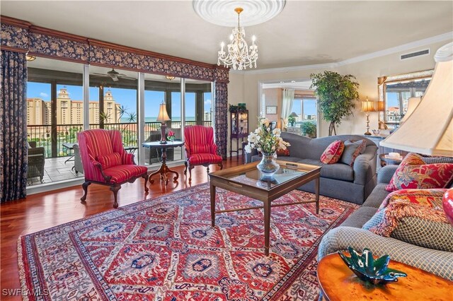 8787 Bay Colony Dr Unit 803, Naples, FL 34108 - living room featuring a chandelier, wood finished floors, and ornamental molding