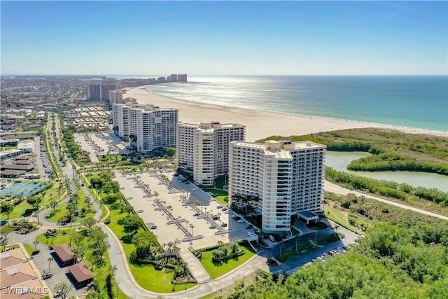 drone / aerial view featuring a water view and a beach view
