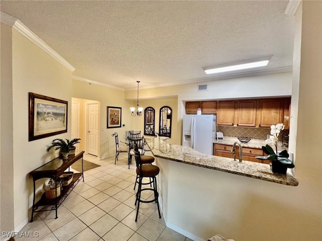kitchen with white fridge with ice dispenser, a textured ceiling, light tile patterned floors, visible vents, and a peninsula