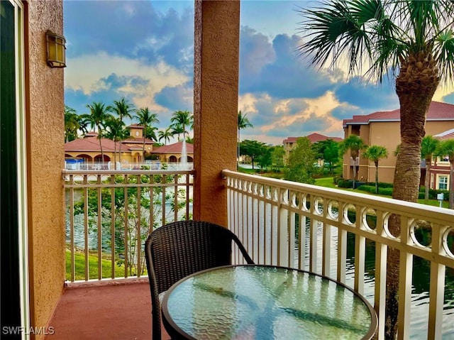 balcony featuring a water view and outdoor dining area