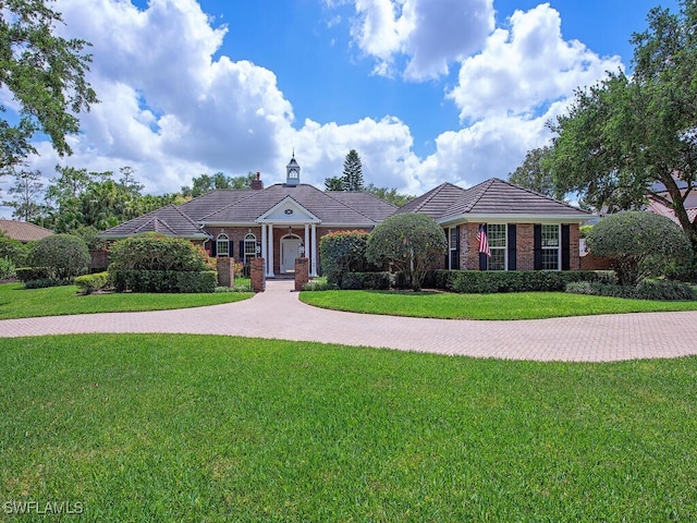 view of front of home featuring a front yard and brick siding