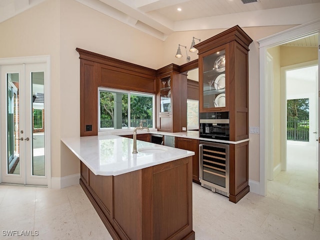 kitchen with lofted ceiling with beams, glass insert cabinets, light countertops, beverage cooler, and brown cabinets