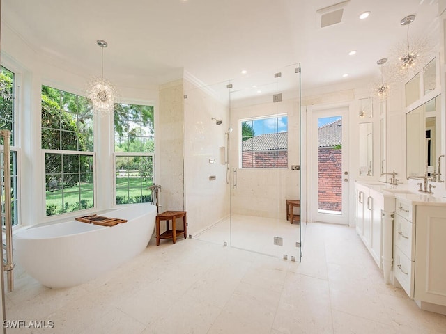 full bath featuring a freestanding bath, an inviting chandelier, crown molding, a shower stall, and vanity