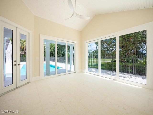 interior space with french doors, ceiling fan, tile patterned floors, and lofted ceiling