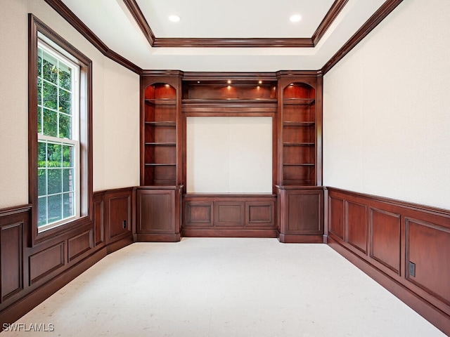 unfurnished room featuring a decorative wall, crown molding, a wainscoted wall, and a raised ceiling
