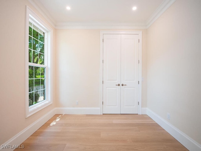 unfurnished room with crown molding, baseboards, and light wood finished floors
