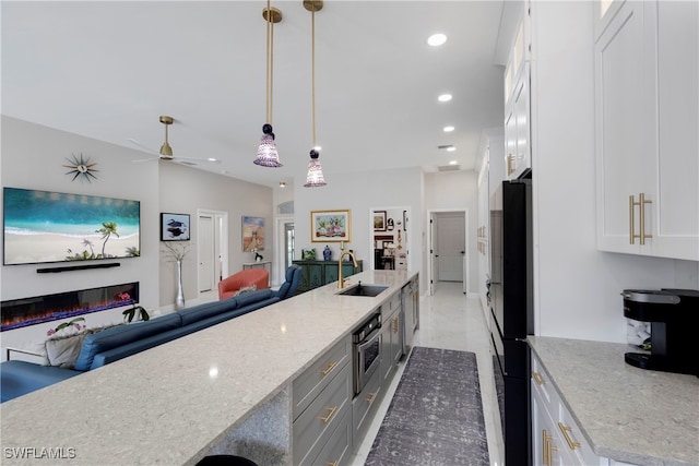 26036 Clarkston Dr, Bonita Springs, FL 34135 - kitchen featuring open floor plan, white cabinetry, stainless steel oven, light stone countertops, and a ceiling fan