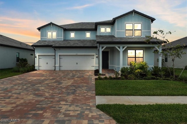 4151 Traditions Dr, Ave Maria, FL 34142 - view of front facade featuring a yard, board and batten siding, decorative driveway, and an attached garage