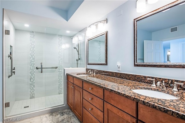 full bath featuring recessed lighting, a shower stall, visible vents, and a sink