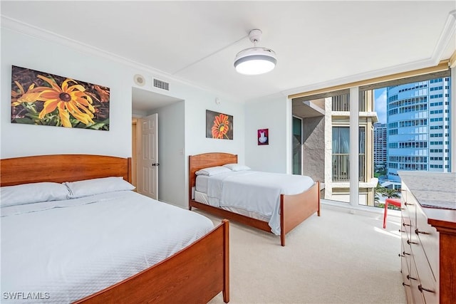 bedroom featuring light carpet, expansive windows, visible vents, and multiple windows