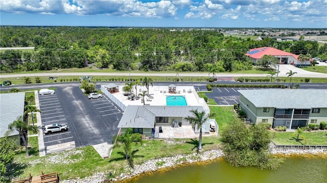 drone / aerial view with a wooded view and a water view