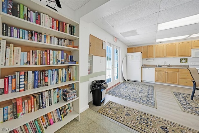 interior space featuring light brown cabinetry, open shelves, a sink, and white appliances