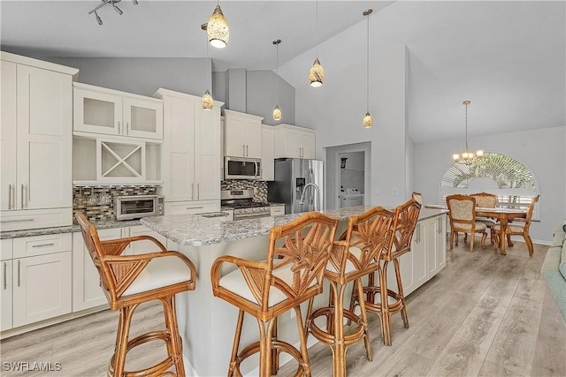 3852 Stabile Rd, Saint James City, FL 33956 - kitchen featuring white cabinets, appliances with stainless steel finishes, backsplash, high vaulted ceiling, and a toaster