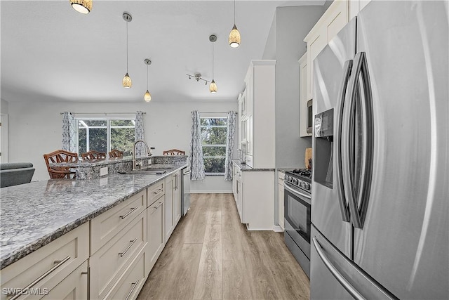3852 Stabile Rd, Saint James City, FL 33956 - kitchen with light wood-style flooring, white cabinets, light stone countertops, stainless steel appliances, and a sink