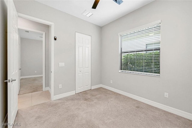 11643 Riverstone Ln, Fort Myers, FL 33913 - unfurnished bedroom featuring a closet, baseboards, tile patterned floors, carpet floors, and ceiling fan