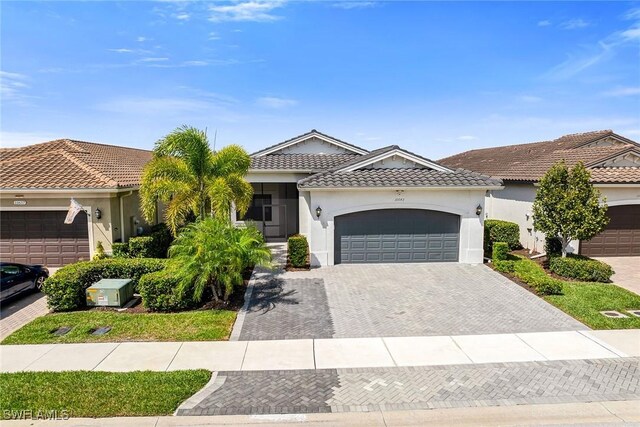 11643 Riverstone Ln, Fort Myers, FL 33913 - view of front of property with a garage, driveway, stucco siding, and a tiled roof