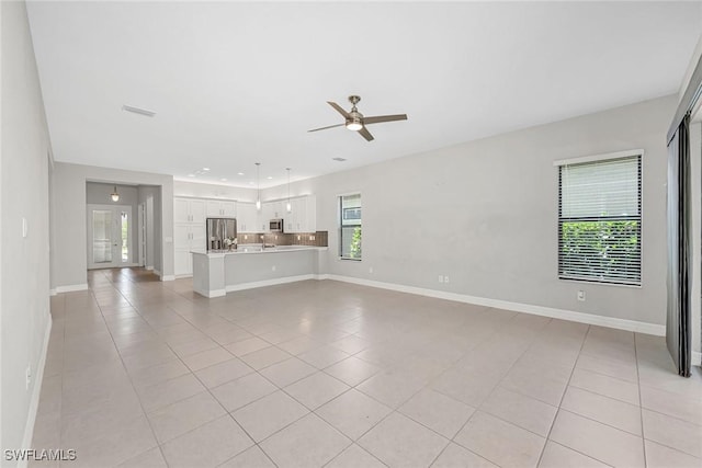 11643 Riverstone Ln, Fort Myers, FL 33913 - unfurnished living room featuring a sink, light tile patterned floors, ceiling fan, and baseboards