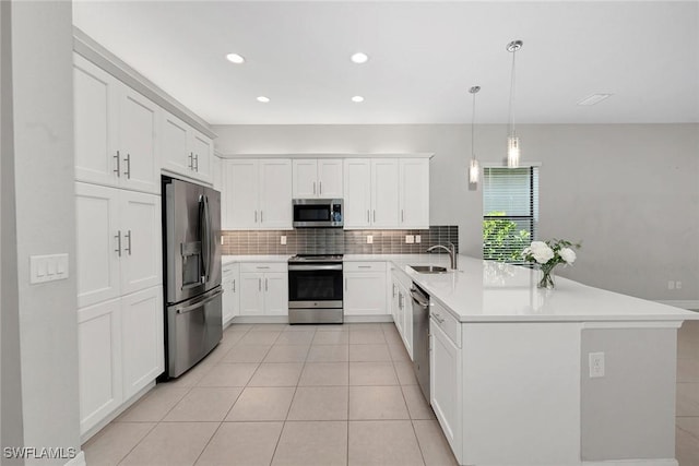 11643 Riverstone Ln, Fort Myers, FL 33913 - kitchen with tasteful backsplash, a peninsula, light countertops, appliances with stainless steel finishes, and a sink