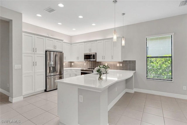 11643 Riverstone Ln, Fort Myers, FL 33913 - kitchen with tasteful backsplash, a peninsula, visible vents, appliances with stainless steel finishes, and light countertops