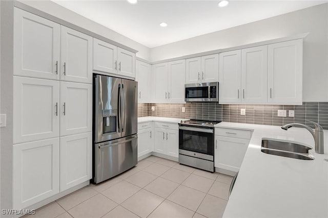 11643 Riverstone Ln, Fort Myers, FL 33913 - kitchen featuring appliances with stainless steel finishes, light countertops, white cabinetry, decorative backsplash, and a sink