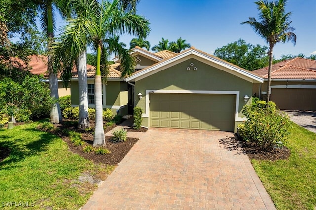 12740 Seaside Key Ct, North Fort Myers, FL 33903 - view of front of home with stucco siding, a garage, a tile roof, decorative driveway, and a front yard