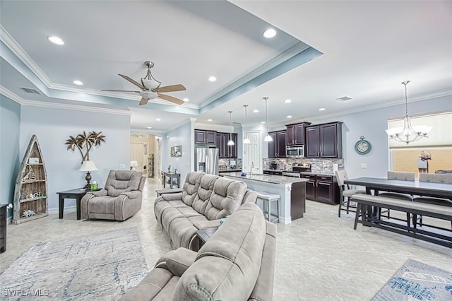 12740 Seaside Key Ct, North Fort Myers, FL 33903 - living area with ceiling fan, a tray ceiling, a chandelier, recessed lighting, and crown molding