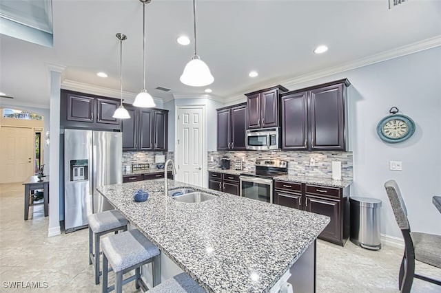 12740 Seaside Key Ct, North Fort Myers, FL 33903 - kitchen with stainless steel appliances, a kitchen breakfast bar, decorative backsplash, a center island with sink, and light stone countertops