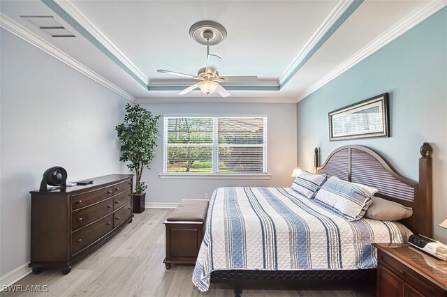 12740 Seaside Key Ct, North Fort Myers, FL 33903 - bedroom featuring a raised ceiling, light wood-style floors, ornamental molding, and a ceiling fan