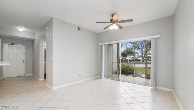 spare room featuring baseboards, visible vents, ceiling fan, and light tile patterned flooring