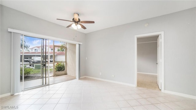 spare room with baseboards, light tile patterned floors, and ceiling fan