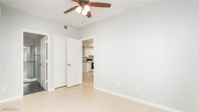 unfurnished bedroom featuring light tile patterned floors, visible vents, ensuite bathroom, and baseboards