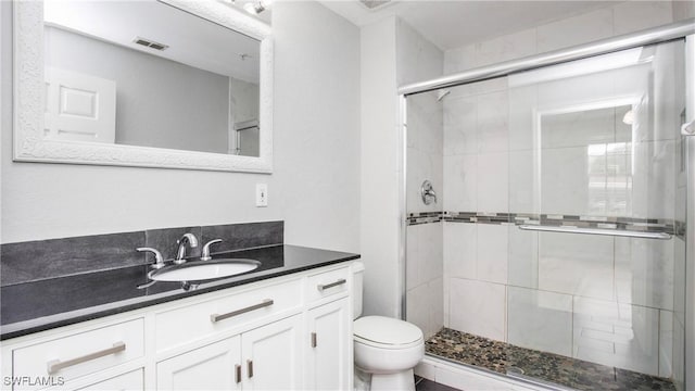 full bathroom with toilet, visible vents, a shower stall, and vanity