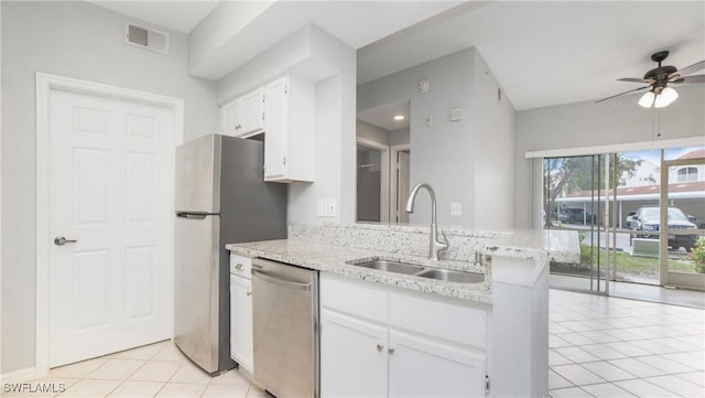 kitchen with light tile patterned floors, appliances with stainless steel finishes, white cabinets, a sink, and visible vents