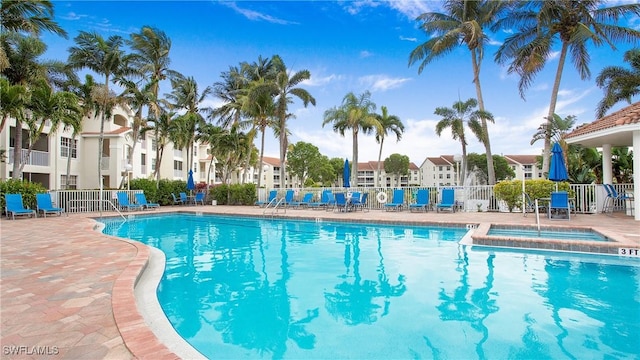 community pool featuring a patio, a community hot tub, and fence