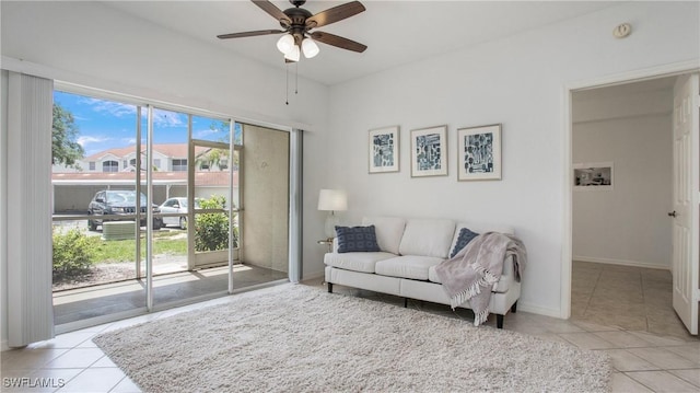 living room with ceiling fan, tile patterned floors, and baseboards