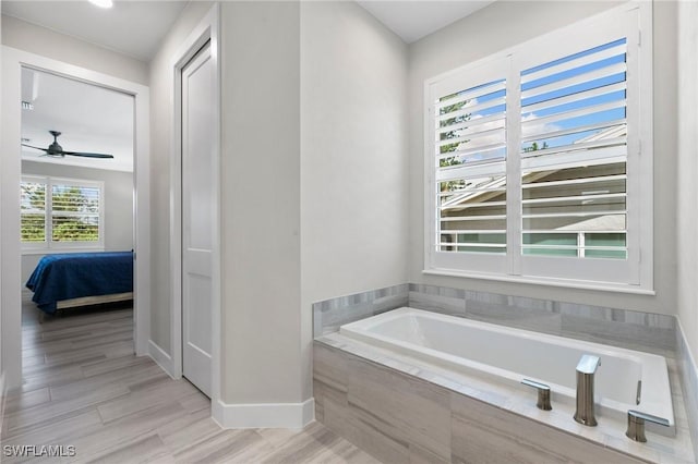 641 Diplomat Ct, Marco Island, FL 34145 - bathroom featuring ceiling fan, ensuite bathroom, a bath, wood finished floors, and baseboards