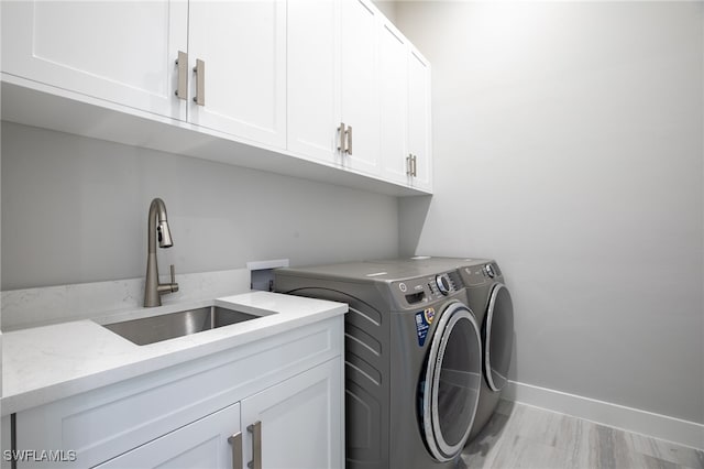 641 Diplomat Ct, Marco Island, FL 34145 - clothes washing area featuring baseboards, washing machine and clothes dryer, a sink, and cabinet space