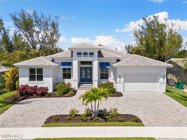 641 Diplomat Ct, Marco Island, FL 34145 - prairie-style house featuring a tiled roof, stucco siding, an attached garage, french doors, and driveway