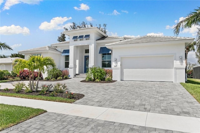 641 Diplomat Ct, Marco Island, FL 34145 - prairie-style house with a garage, stucco siding, a tiled roof, and decorative driveway