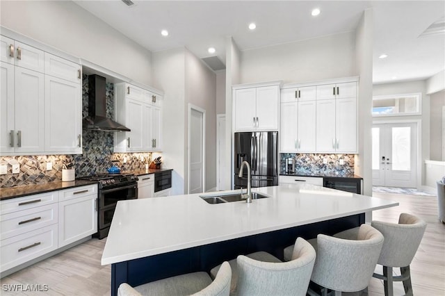 641 Diplomat Ct, Marco Island, FL 34145 - kitchen featuring stainless steel refrigerator with ice dispenser, wall chimney exhaust hood, a sink, a kitchen bar, and range with two ovens