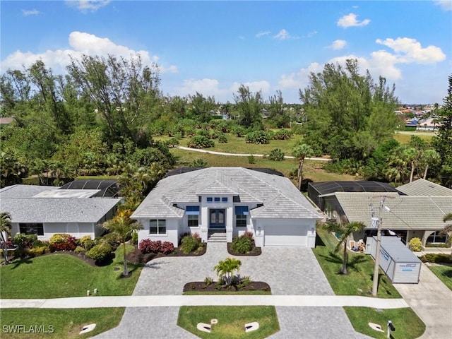 641 Diplomat Ct, Marco Island, FL 34145 - view of front of property featuring stucco siding, decorative driveway, a front lawn, an attached garage, and glass enclosure
