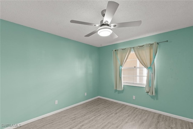 empty room featuring wood finished floors, a textured ceiling, a ceiling fan, and baseboards