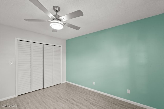 unfurnished bedroom with baseboards, wood finished floors, and a closet