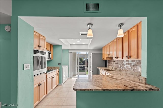 kitchen featuring visible vents, light tile patterned floors, a sink, tasteful backsplash, and appliances with stainless steel finishes